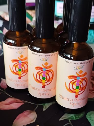Three bottles of chakra spray, the label is light pink with 7 coloured dots to represent each chakra and some reiki symbols
