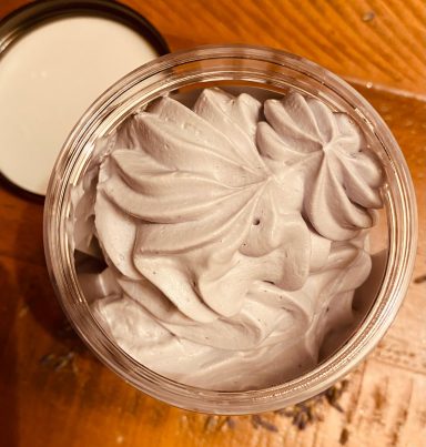 A picture of the inside of some body butter, lilac, creamy and whipped 